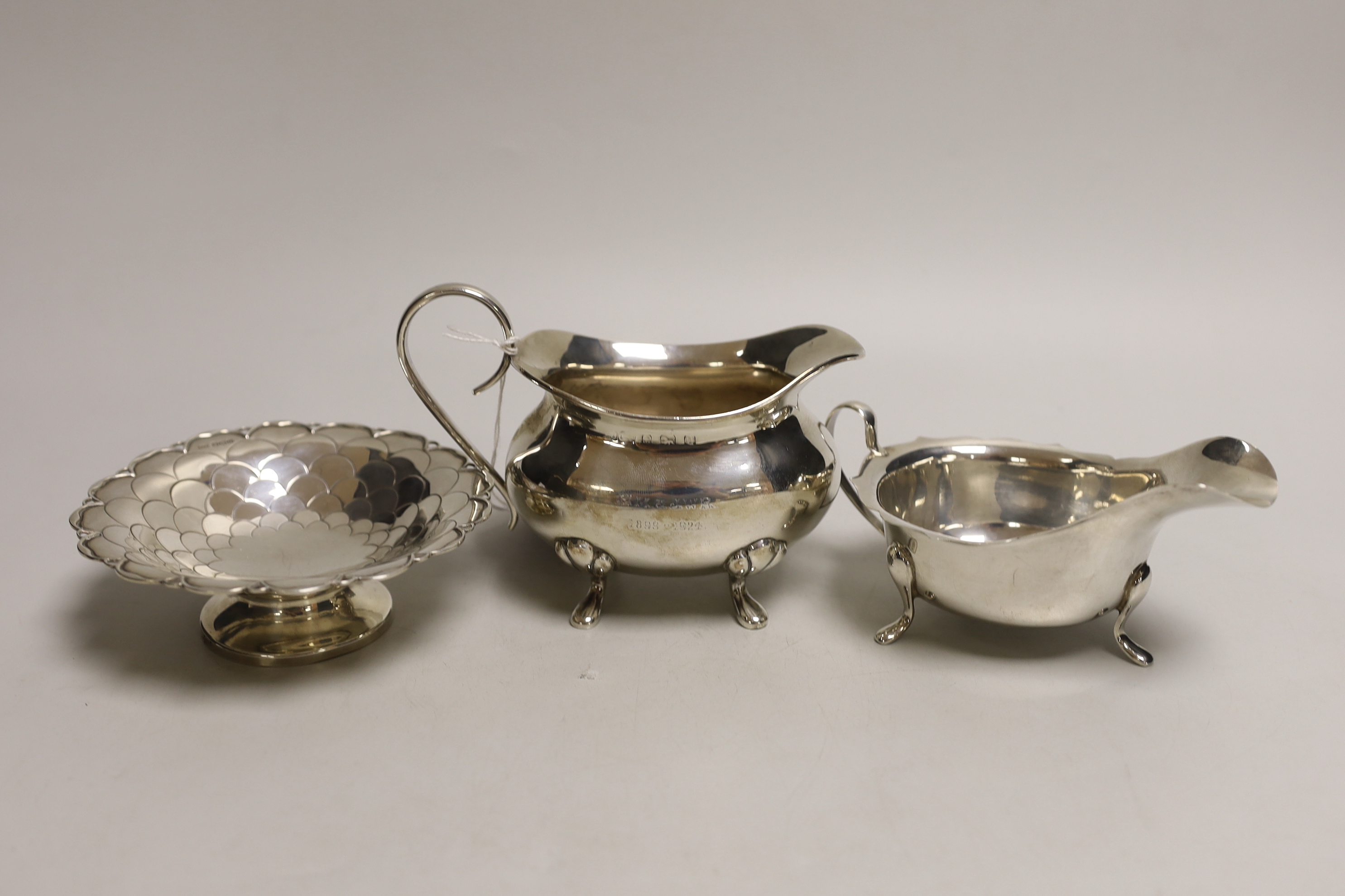 A George V silver cream jug, a George V silver sauceboat and a George V silver circular scale work bon bon bowl, 12.8oz.
